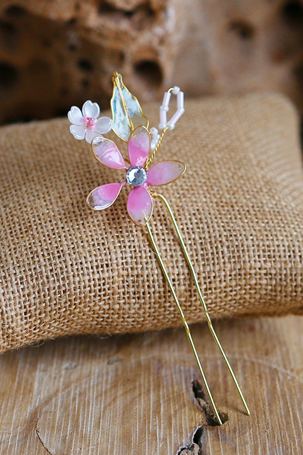 Handmade pink resin floral bridal hair pin with crystal centre and gold wire detailing, lightweight and waterproof wedding hair accessory.