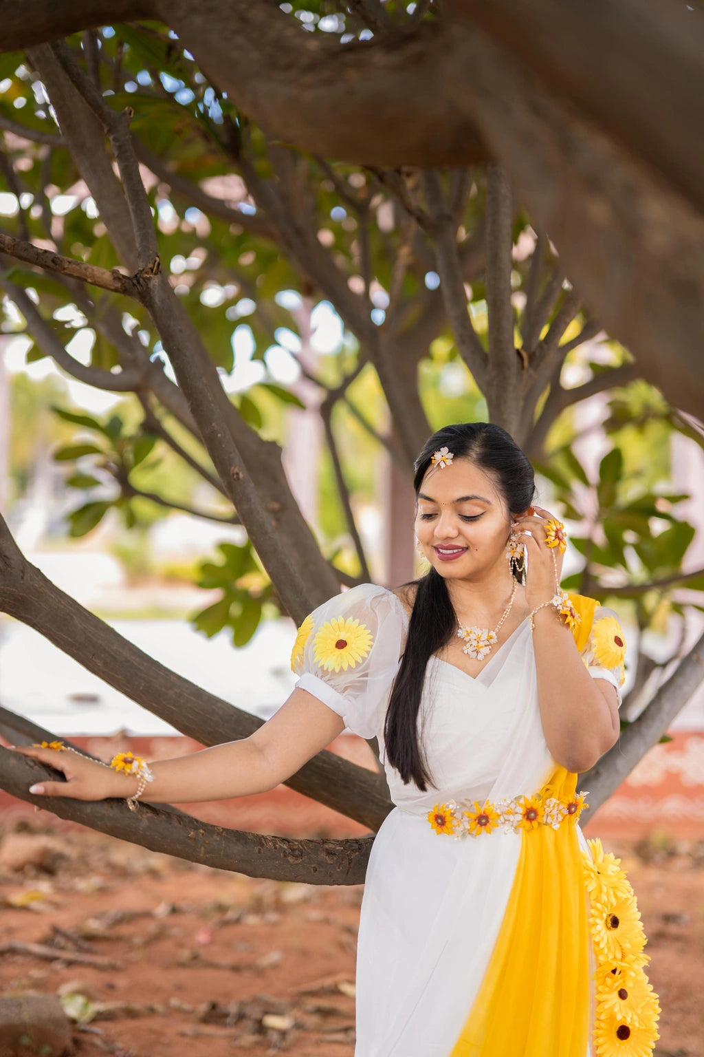 Our beautiful Bride waring our Handmade resin sunflower waistbelt with white blossoms, gold-plated copper wire, and pearl accents – customizable lightweight bridal kamarband for Haldi & Mehndi.