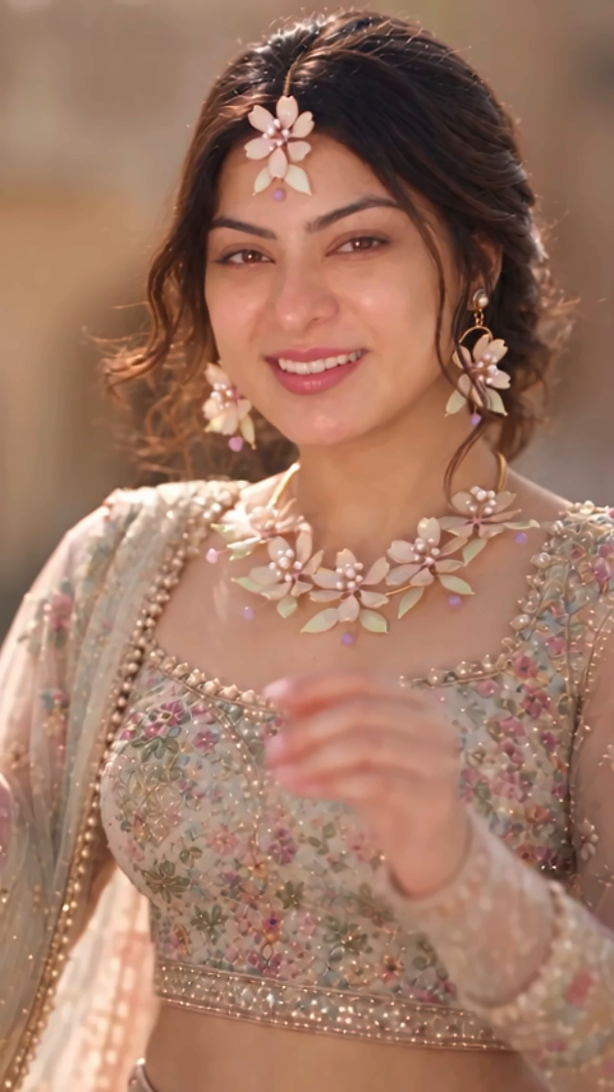 Smiling bride wearing a blush pink resin flower bridal jewelry set with necklace, earrings and maang tikka
