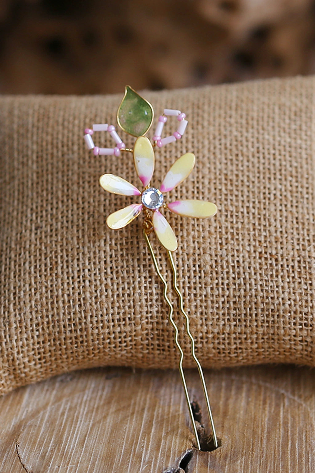 Handmade resin floral bridal hair pin with pastel yellow petals and green leaf, lightweight waterproof wedding hair accessory for bridal bun