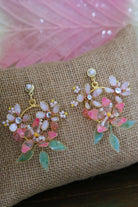 Handmade blush pink resin floral earrings with pearls and green leaves on burlap