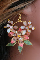 Handmade blush pink resin floral earrings with pearls and green leaves  on model