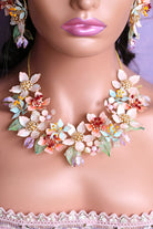 Coral Caress bridal necklace crafted from resin flowers in coral, peach, and white, with gold-plated detailing and soft green leaves – lightweight customizable statement necklace for brides.