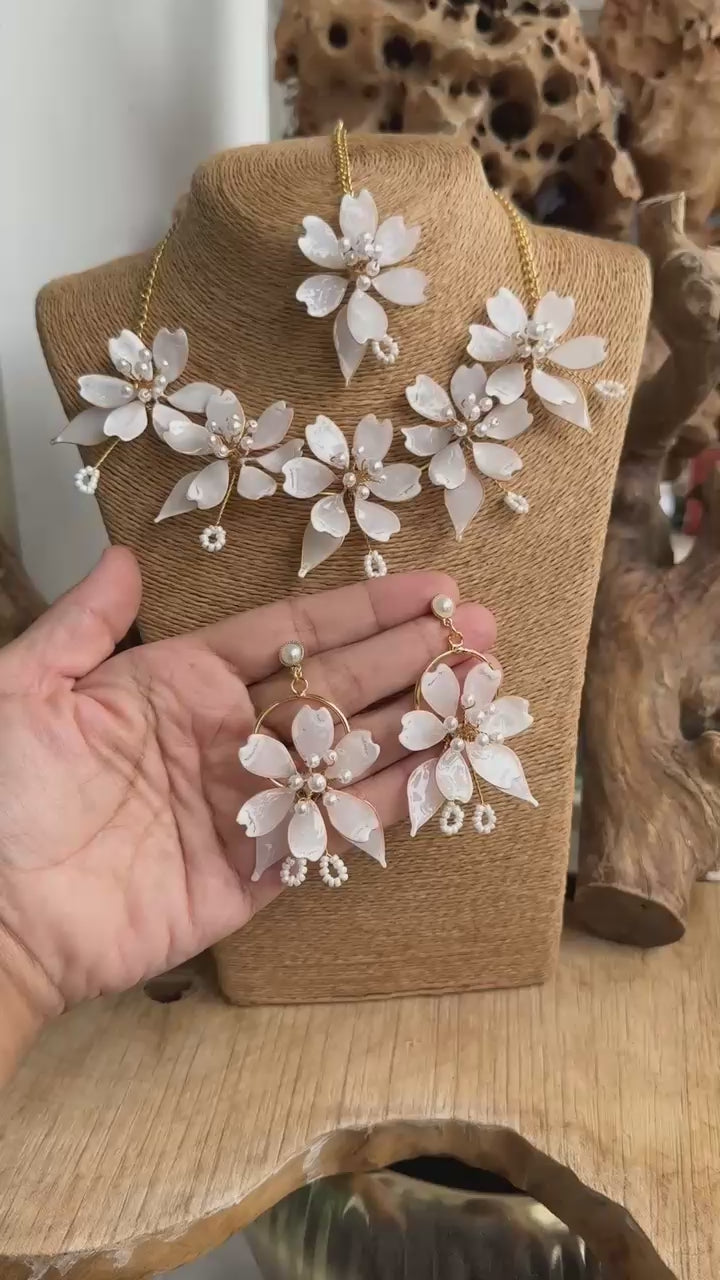 Video of White Pearl Resin Flower Bridal Jewelry Set showing necklace and earrings held in hand